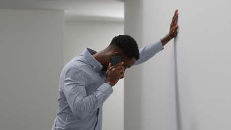 young businessman in office talking on mobile phone reacting to bad news looking unhappy and depressed 2