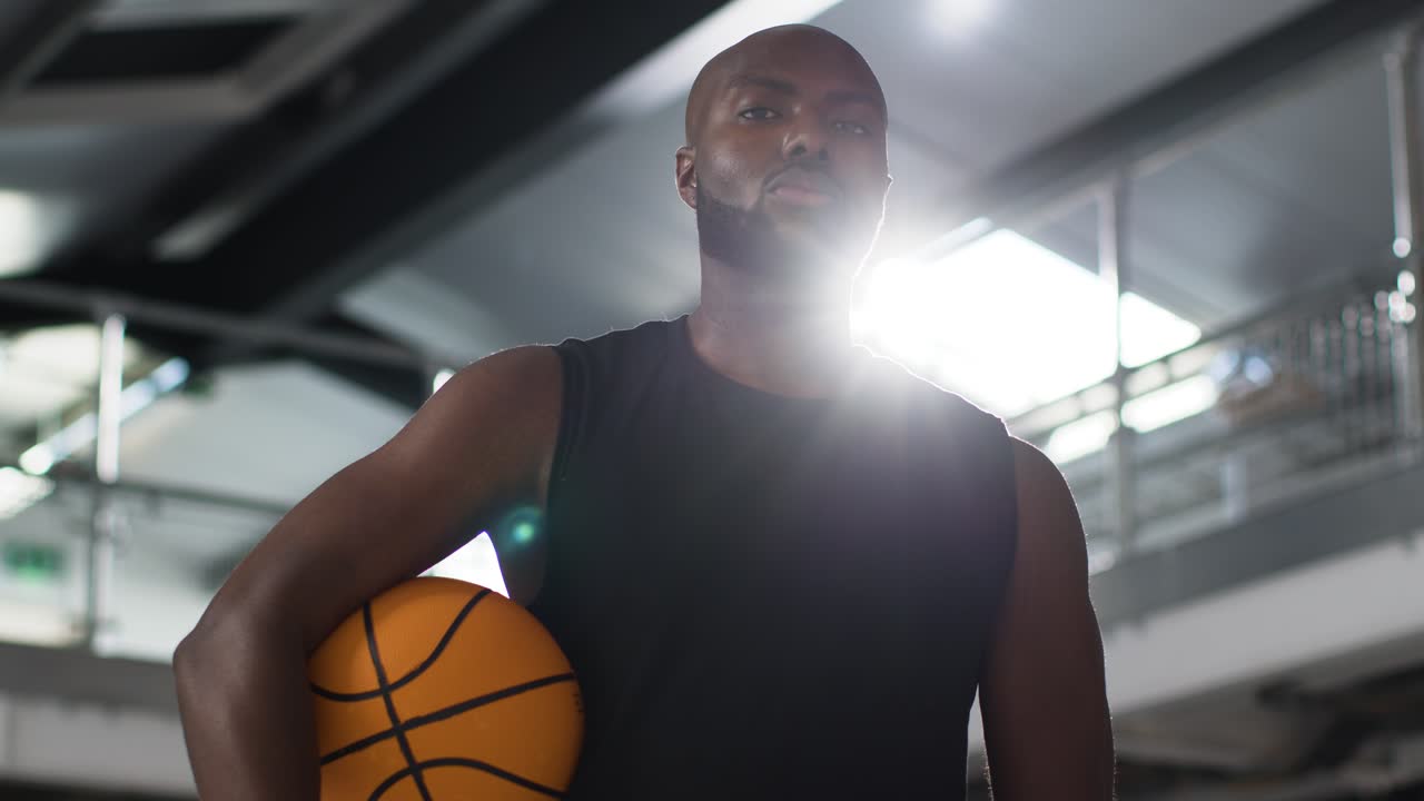retrato de un jugador de baloncesto en la cancha sosteniendo la pelota bajo el brazo 1