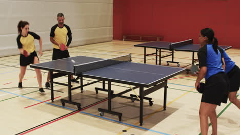 playing table tennis, two teams competing in indoor sports hall