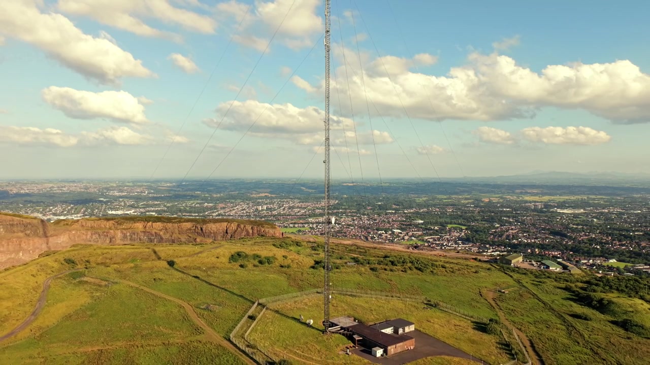 Video aereo 4K 60FPS che si allontana dalla stazione trasmittente di Black Mountain a West Belfast, Irlanda del Nord, nel Regno Unito, in una giornata di sole splendente. Prodotto con colore Rec709.
