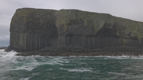 lento dolly disparado más allá de la cueva de fingerls que muestra las rocas de basalto en la isla de staffa