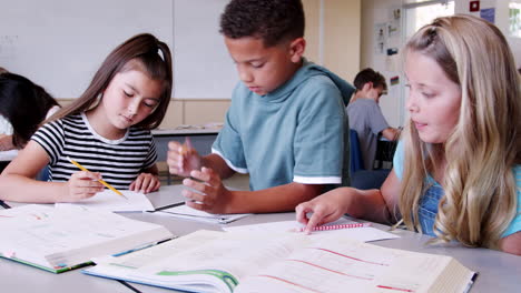 tres alumnos trabajando juntos en la lección de la escuela primaria