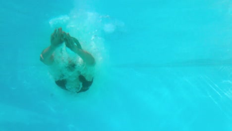 fit woman diving into the outdoor pool