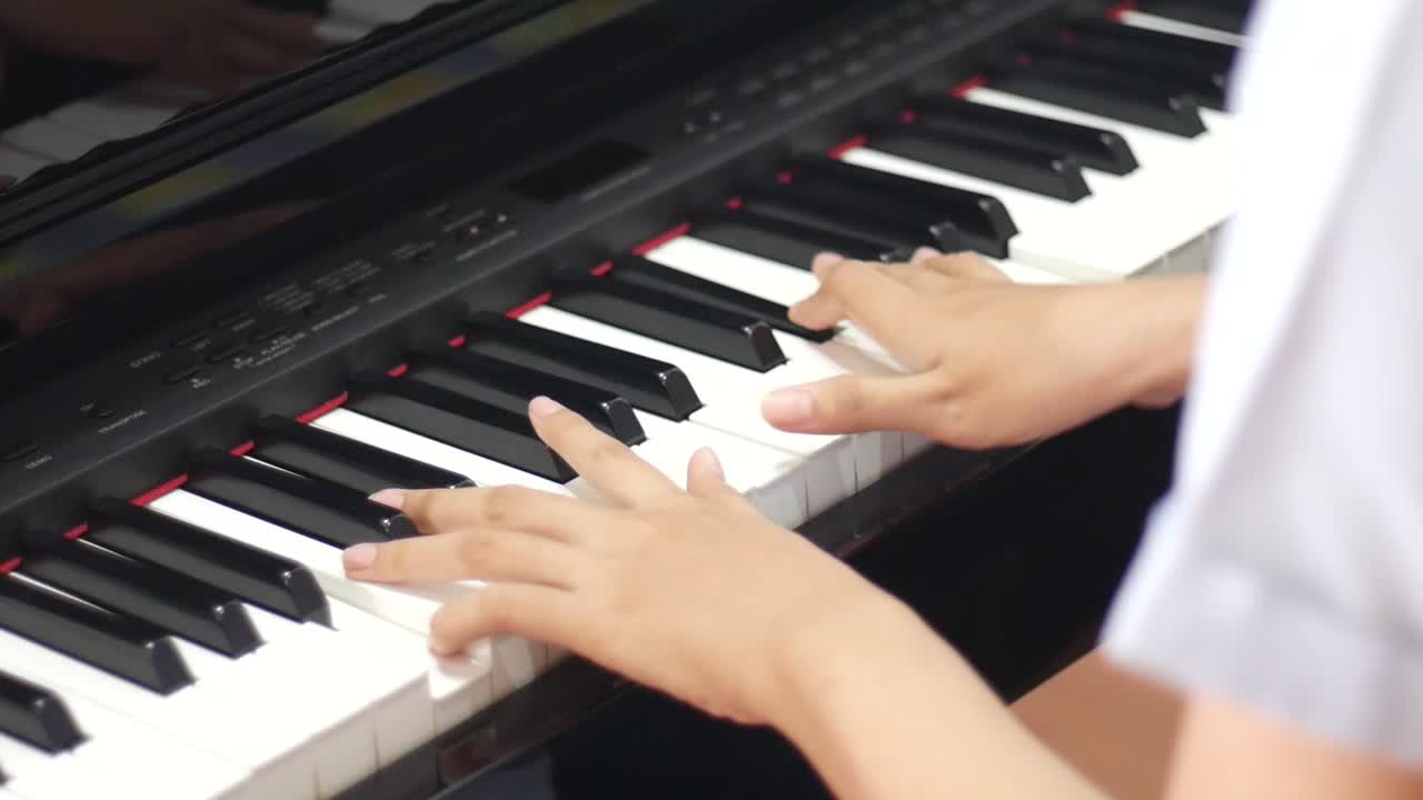 소녀의 손이 피아노를 친다. 측면보기