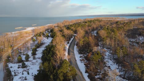aerial pull out from a snow covered presque isle at sunset in erie, pa.
