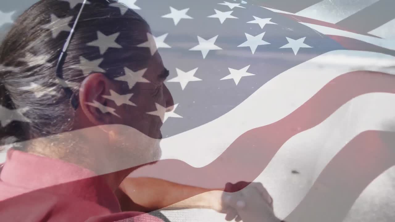 animación de un anciano biracial en la playa sobre la bandera de los estados unidos
