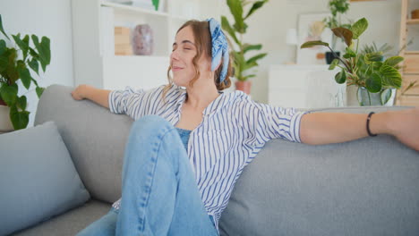 Joyful-Woman-Dreaming-with-a-Smile-on-Sofa