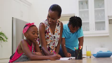 Madre-Afroamericana-Ayudando-A-Su-Hija-Y-A-Su-Hijo-Con-La-Tarea-En-Casa