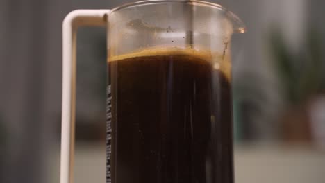 stirring coffee grounds in a french press