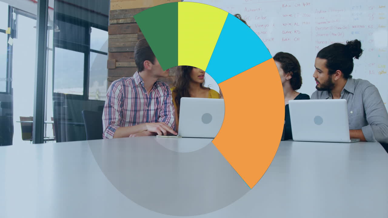 Team members typing on laptops in business meeting room, showing animated charts and data streams