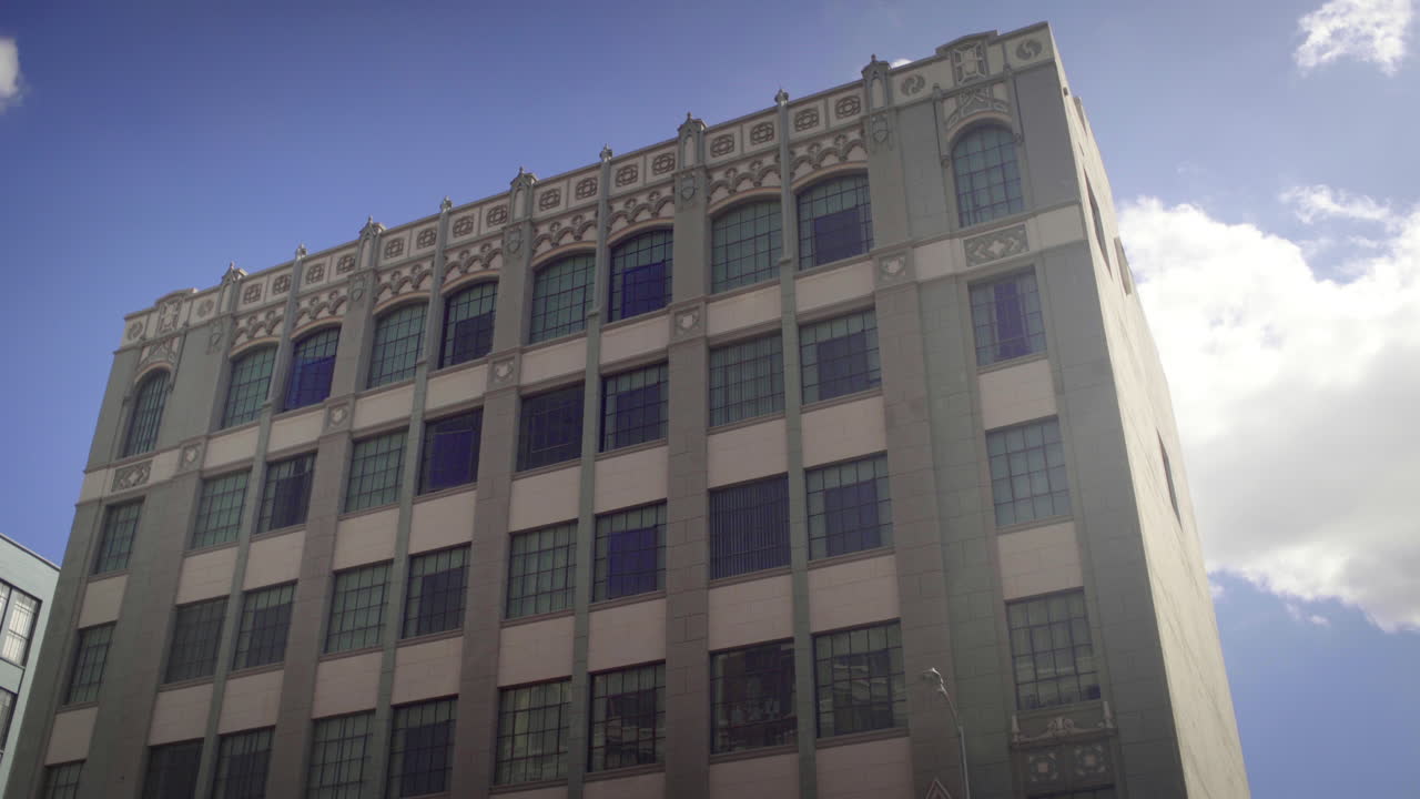 View of a large historic building with many windows against a blue sky