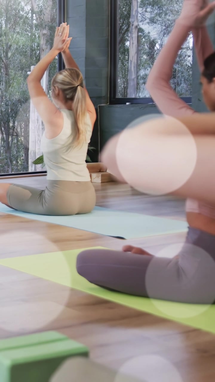 Video verticale: Donna sul tappetino solleva i palmi sopra la testa inspirando per l'allineamento yoga, con effetto bokeh che compare.