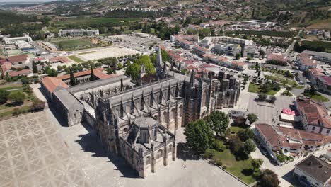 Cityscape-of-Batalha-and-majestic-Unesco-monastery-building,-aerial-orbit-view