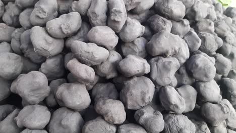 close up of fresh organic raw water chestnuts on a black-colored wooden surface