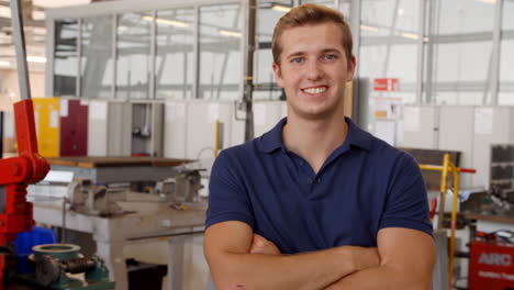 retrato de un ingeniero caminando hacia la cámara en un taller