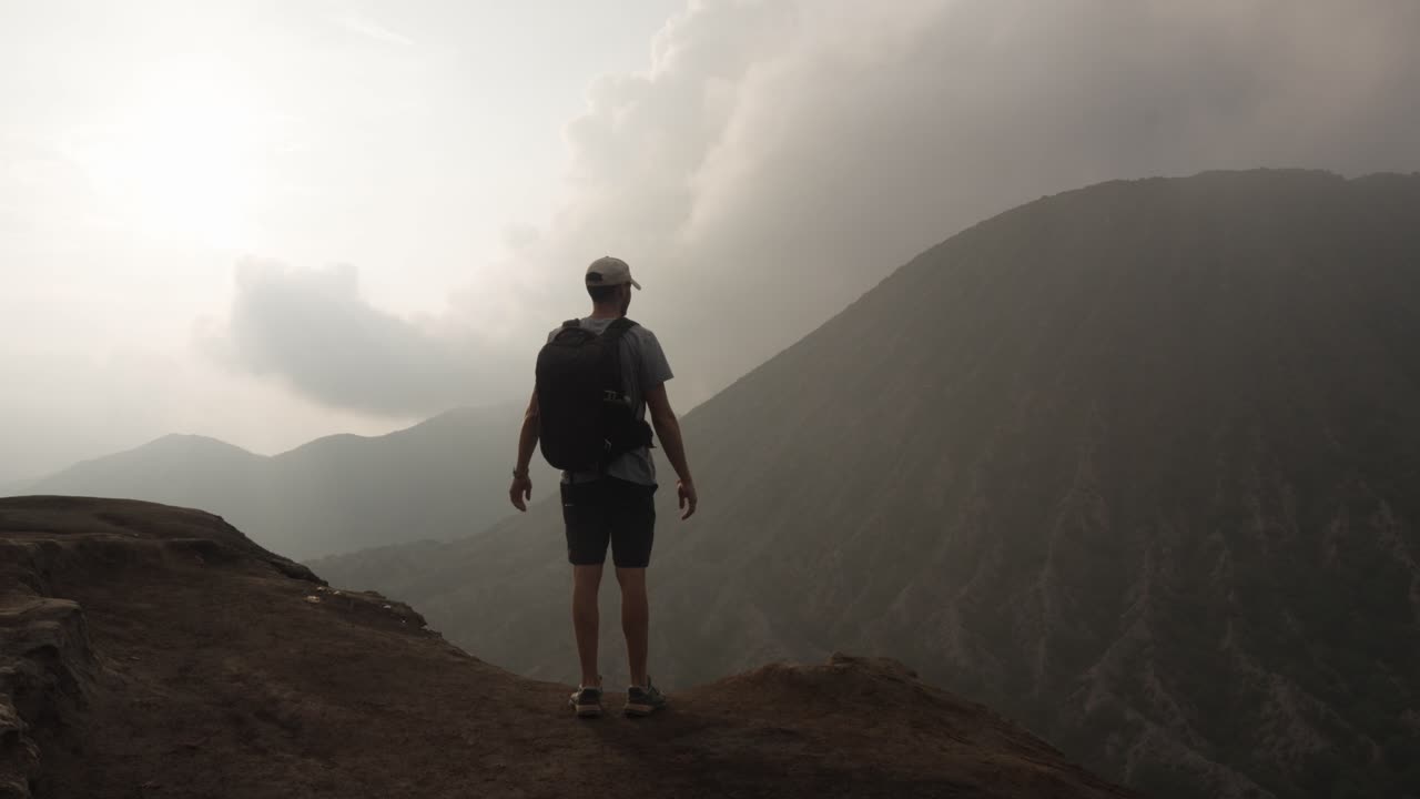 Mount Bromo active volcano crater sulfur steam gray landscape tourist at viewpoint