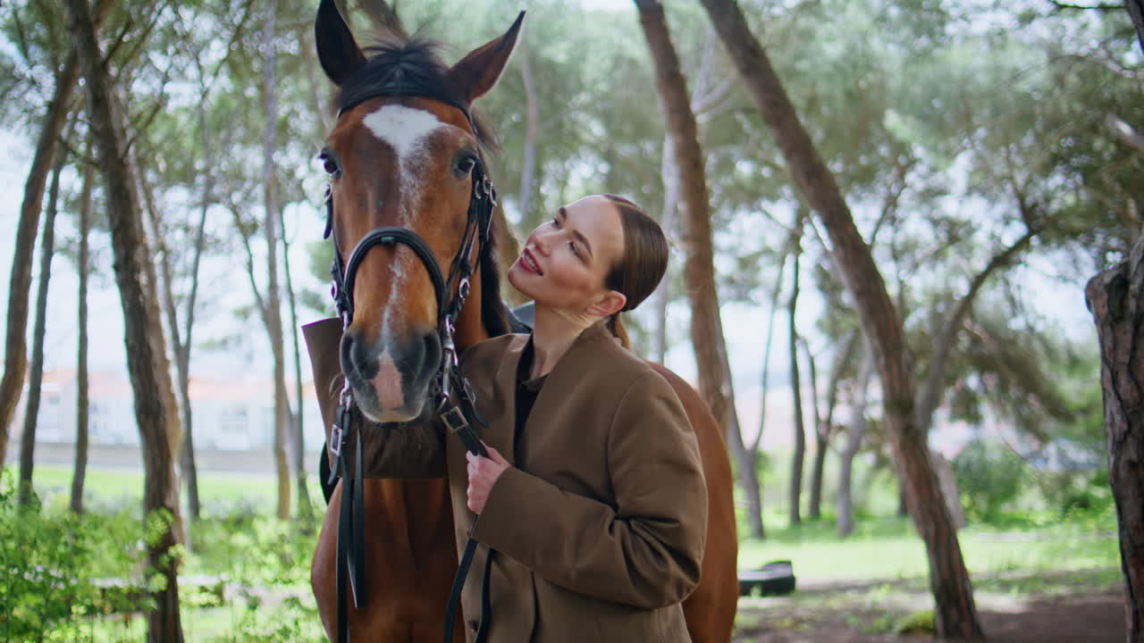 Gentle model bonding horse at farm portrait. Happy cowgirl looking camera ranch