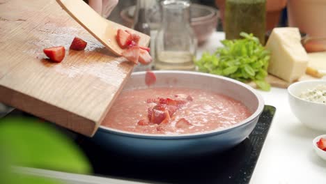 chef añadiendo fresas cortadas en el risotto