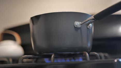 pot on top of stove with blue gas flame under