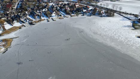 people enjoying themselves on a frozen lake on a sunny winter day in the netherlands