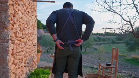 el hombre cocinero ata su delantal detrás de su espalda es un paisaje mediterráneo