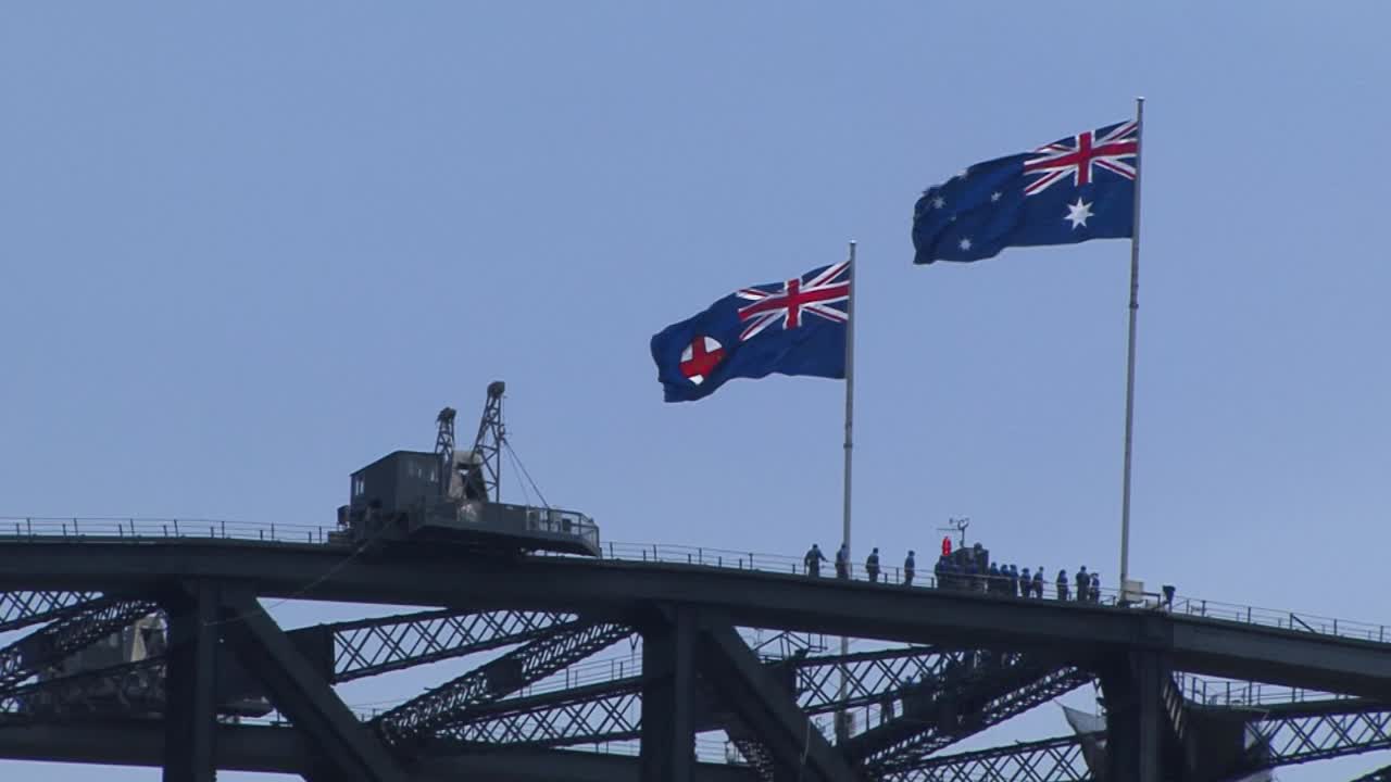 Flags of New South Wales state and Australia on top of the Sydney Harbour Bridge, one of the landmarks of Sydney, Australia.