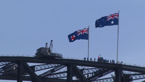 flags of new south wales state and australia on top of the sydney harbour bridge, one of the landmarks of sydney, australia.