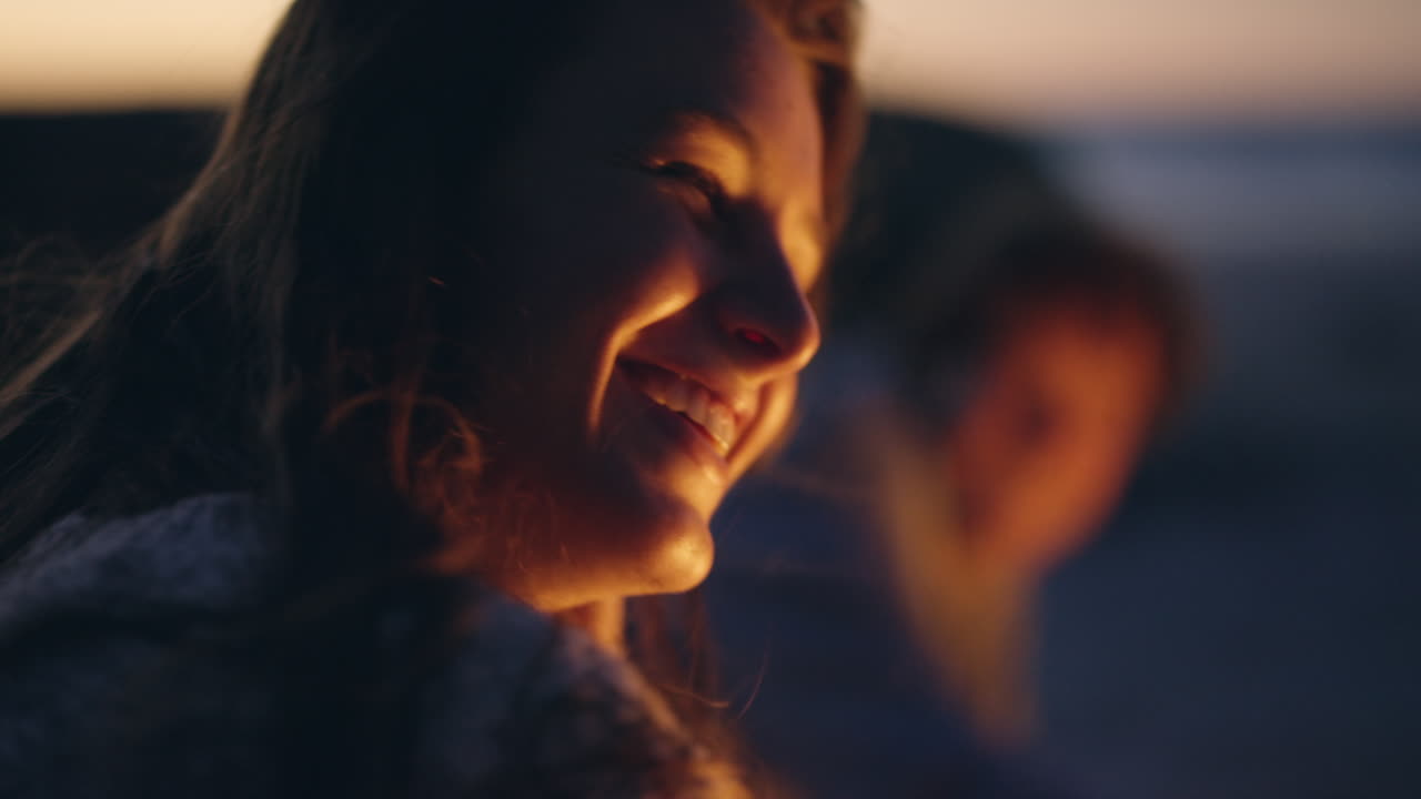 日没時にキャンプファイヤーを楽しんでいるカップル