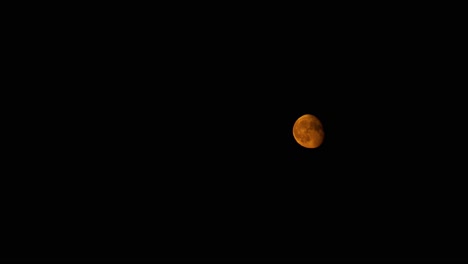 Majestic-red-moon-in-night-sky-with-flowing-clouds,-time-lapse