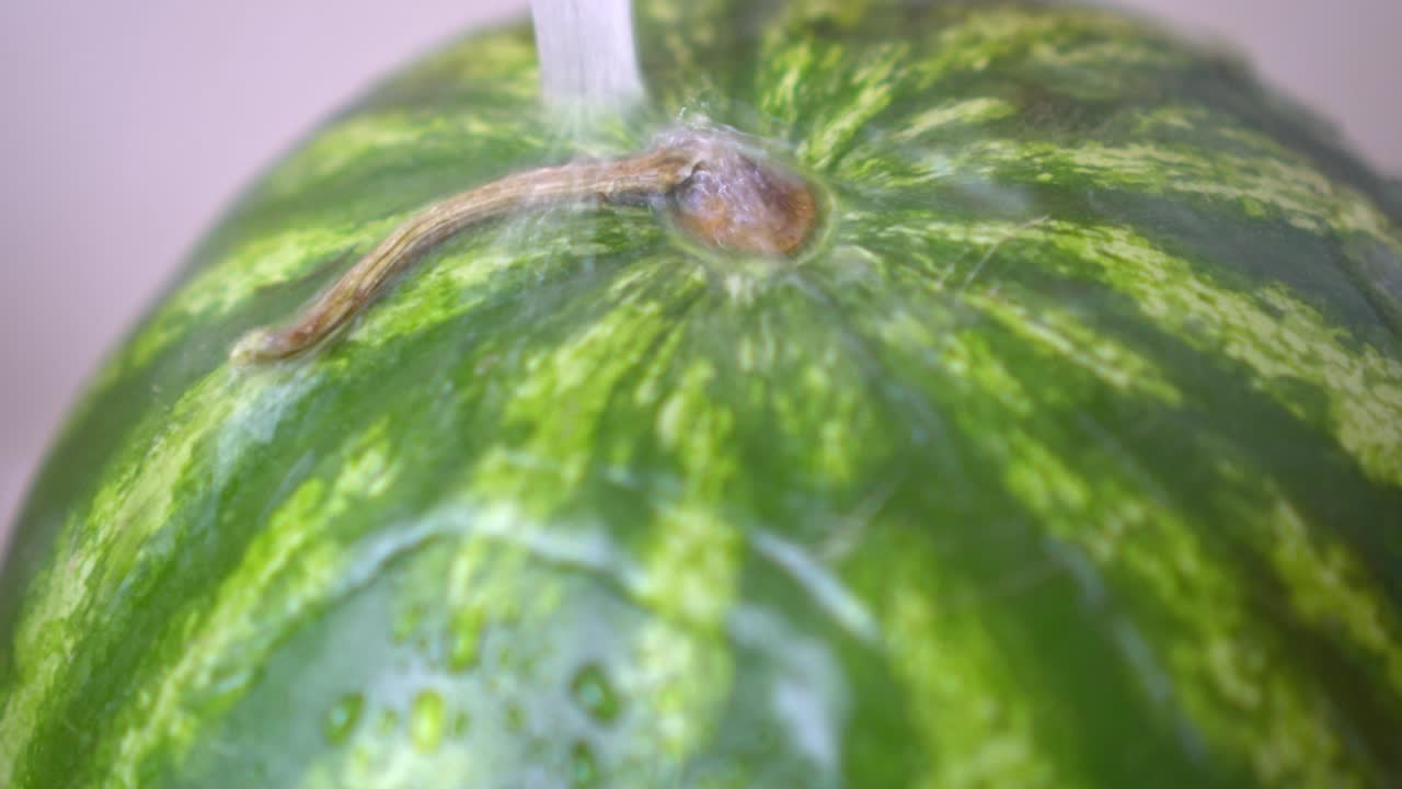 lavar la sandía bajo agua fría del grifo