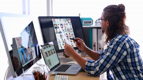 ejecutivo masculino trabajando en una computadora portátil y tableta gráfica en su escritorio 4k
