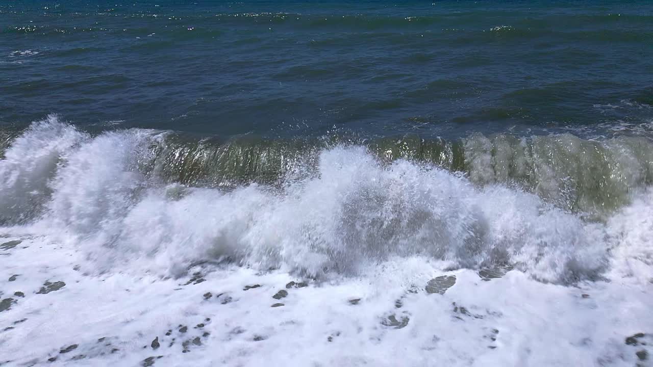 Crashing waves on the beach. Slow motion. Aerial view. Wave foam. Coastline. Andalusia. Spain.
