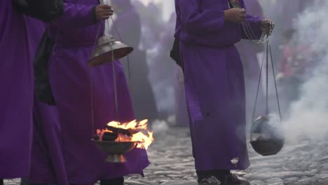 purple robed priests carry incense burners in a colorful christian easter celebration in antigua guatemala