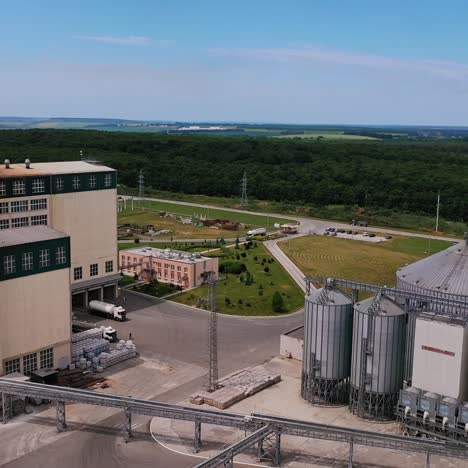 grain terminals, cargo trains and lorries carrying crop on a modern plant. grain storage tanks view from above