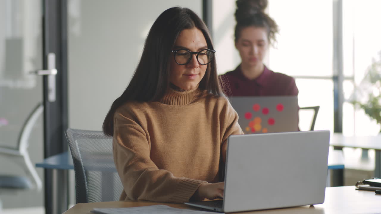 mujer morena trabajando en una computadora portátil en la oficina