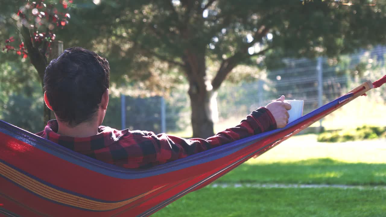 Man Relaxing in Hammock in the Backyard