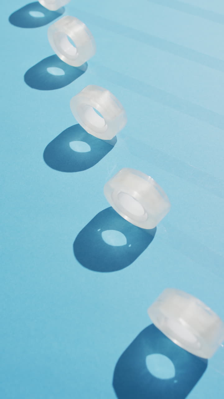 Vertical video of rolls of sellotape on blue background with copy space