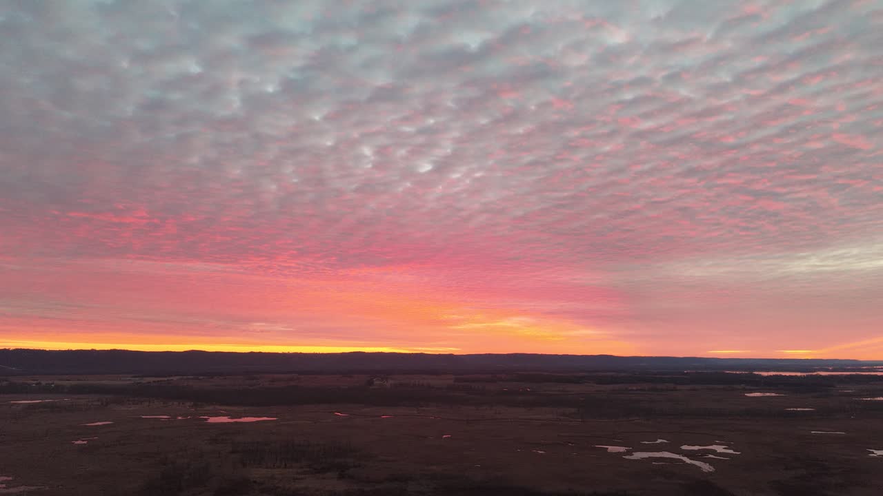 Vista aerea di un tramonto vibrante rosa e arancione su un paesaggio rurale