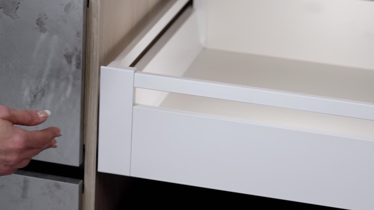 mujer con uñas pintadas abre y cierra el cajón del armario