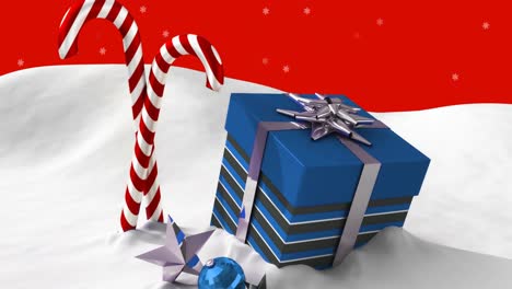 candy cane and christmas gift box on snow against snowflakes floating on red background