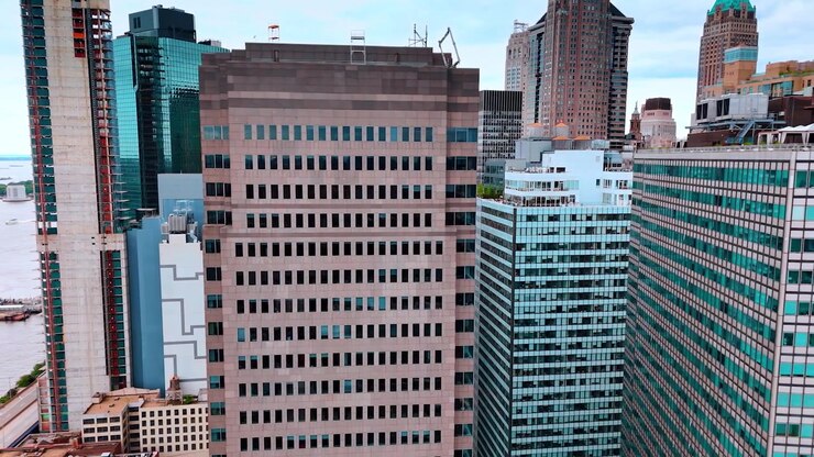 Grattacieli e strade della moderna New York, USA. Volo di un drone lungo le facciate dei grattacieli in avvicinamento al lungofiume