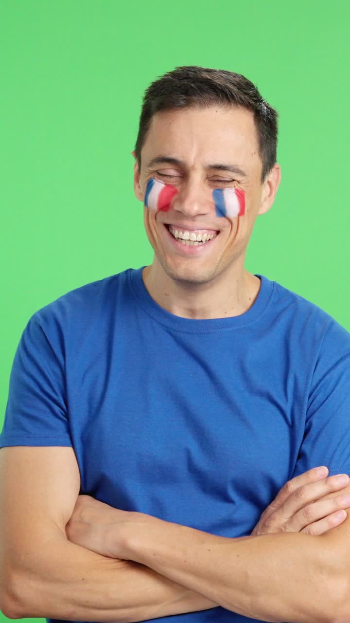 Man standing with french flag painted on face smiling