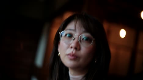 woman adjusting sunglasses and covering mouth
