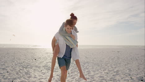 young couple holding hands walking towards sunset on empty beach