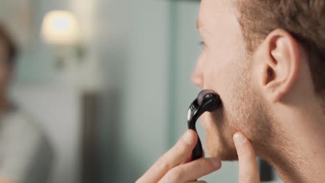 primer plano de un mesoroller masajeando la barba de un hombre