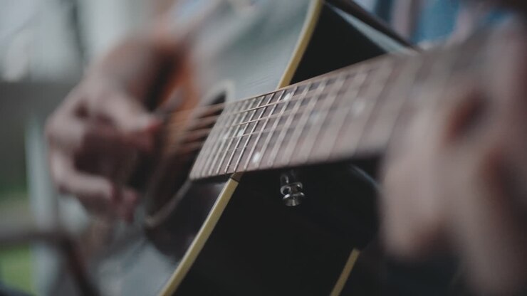 アコースティックギターを演奏している人のクローズアップ