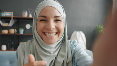 smiling woman in hijab taking a selfie or video call
