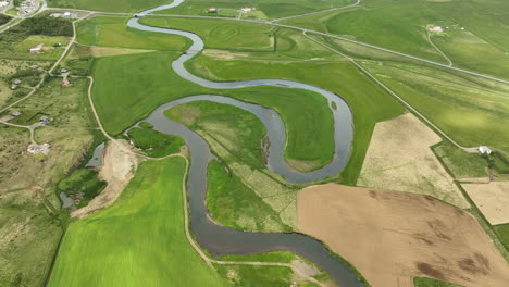 winding river in grasslands green field aerial shot iceland