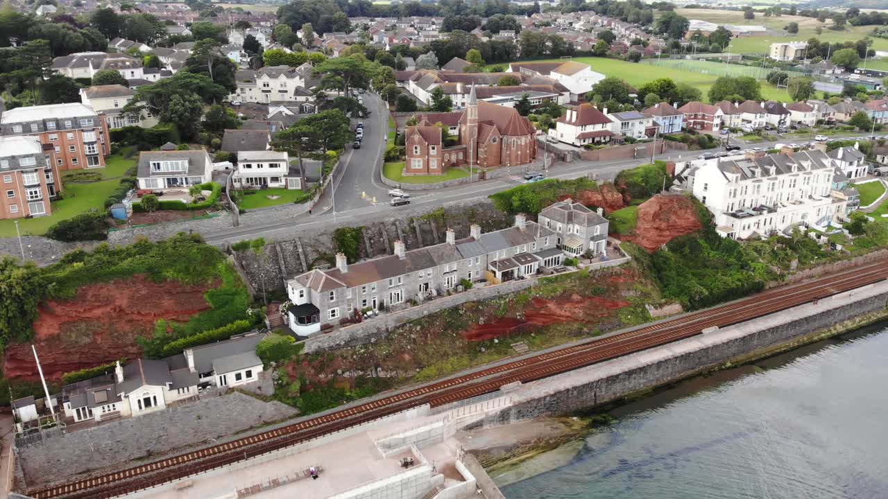 Aerial view of the railway line running along the coast in Dawlish, a charming town in Devon, UK, showing the seawall and the residential area.circle dolly