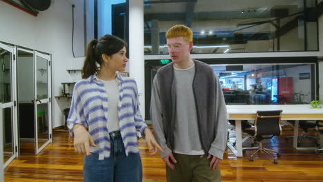 young colleagues walking through office and having discussion